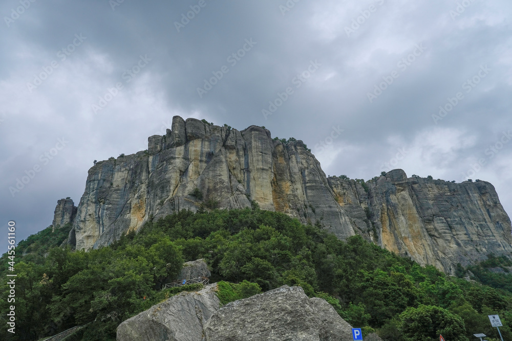 View of the Pietra di Bismantova rock in Italy, Reggio Emilia from beneath across dramatic sky. Mountains landscape