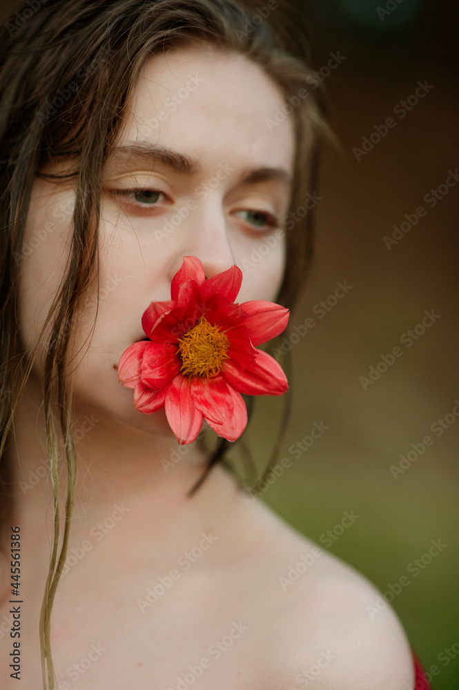girl holding a red flower in her mouth. Concept photo