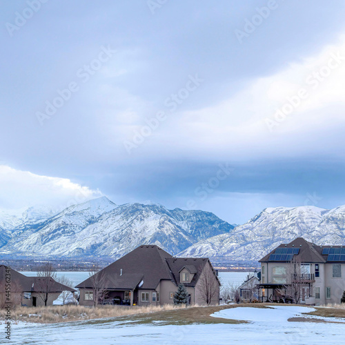 Square Lake front homes on a snowy neighborhood setting with Wasatch Mountains view © Jason