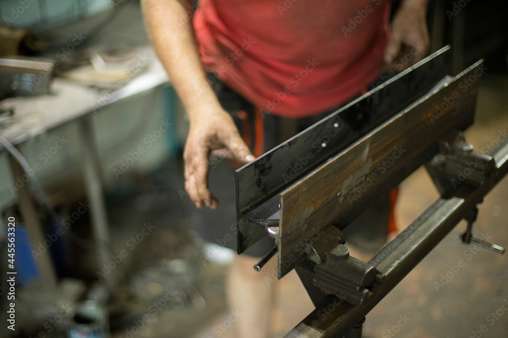 A metal part in the workshop. A man prepares metal for processing.