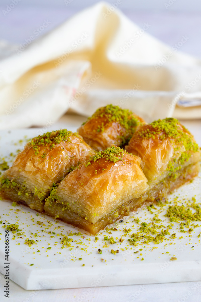 Baklava with pistachio on a white wooden background. Baklava on a marble floor. Close up