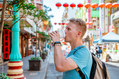 A young man walks around Chinatown and drinks coffee. San Francisco, USA - 18 Apr 2021