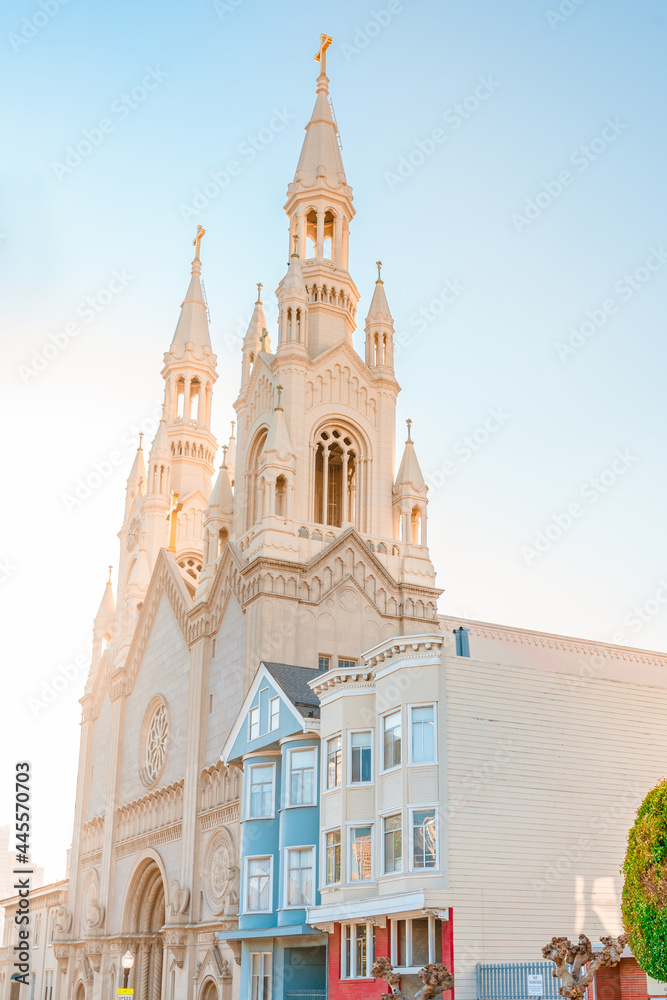 Facades of beautiful houses and a church in San Francisco at sunset