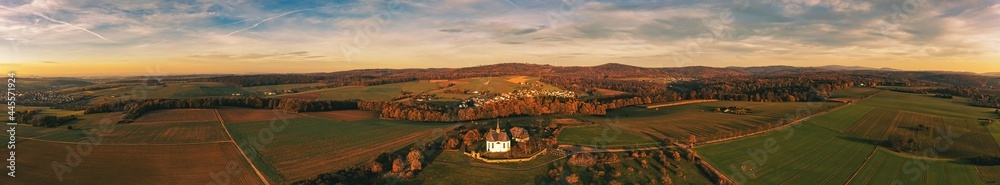 Panorama from a bird's eye view of the Taunus landscape in the evening light with the Cross Chapel of Bad Camberg / Germany