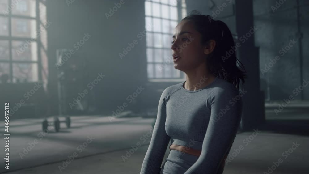 Woman sitting on floor during fitness training in gym. Athlete breathing heavy Woman sitting on floor during fitness training in gym. Athlete breathing heavy