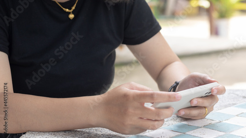 Woman's hands holding or using smartphone with two hands.