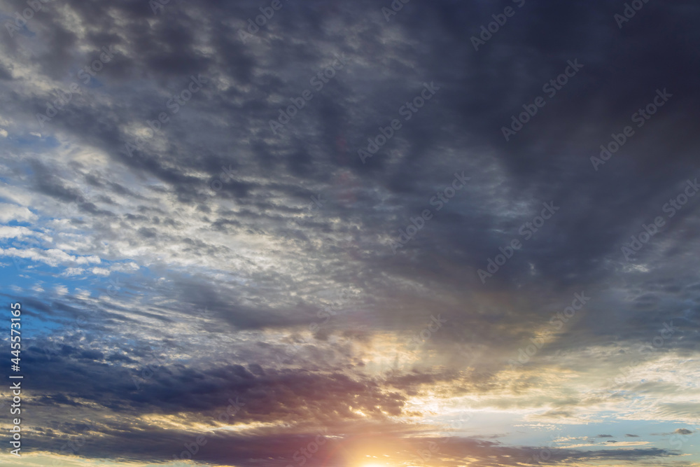 Romantic colorful sunset at the sun go down, blue and orange clouds flow in sky majestic