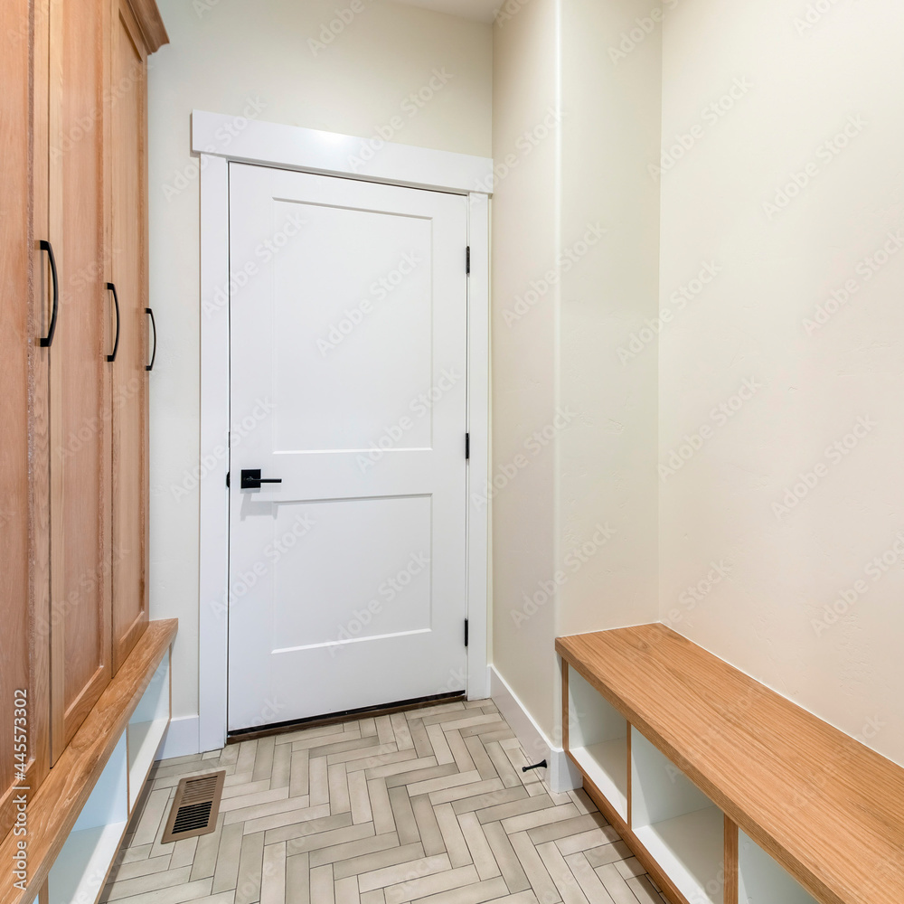 Square frame Mudroom interior with herringbone tile pattern flooring and wooden cabinet Square frame Mudroom interior with herringbone tile pattern flooring and wooden cabinet