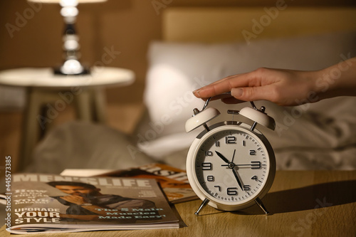 Woman with alarm clock in b...