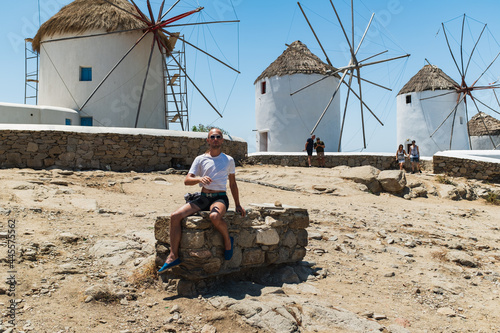 Young Gay Man Posing in Front of Iconic Windmills in Mykonos, Greece