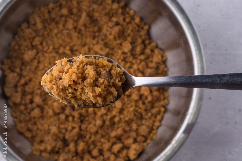 palm sugar on a spoon, golden brown color unrefined sugar product also