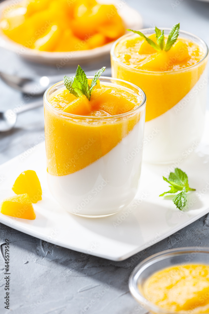 Glass of homemade panna cotta with mango sauce Glass of homemade panna cotta with mango sauce
