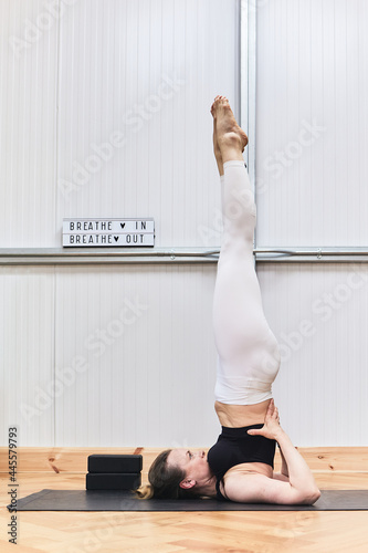 yoga trainer performing a complicated inverted exercise. sport concept