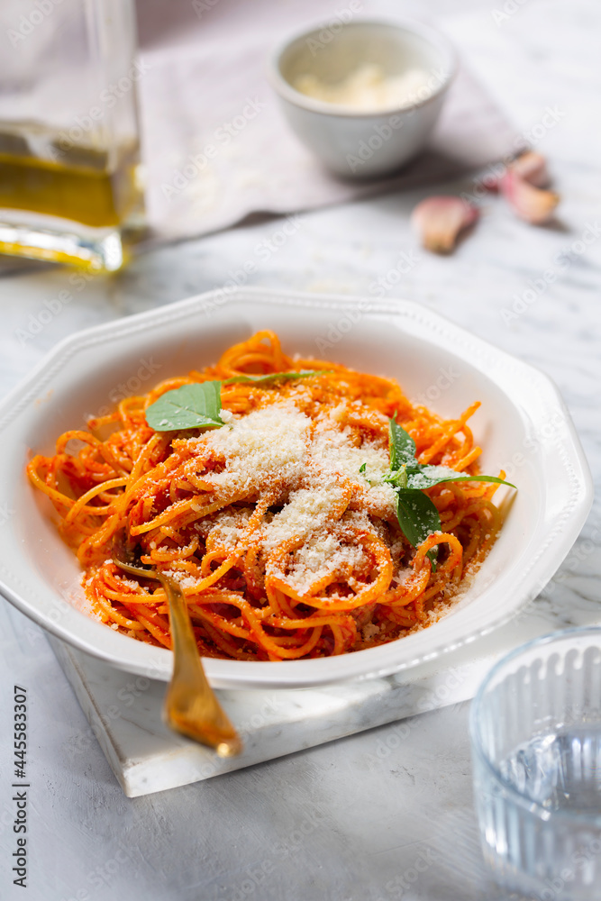 A person's hands are sprinkled with parmesan cheese pasta in tomato sauce A person's hands are sprinkled with parmesan cheese pasta in tomato sauce