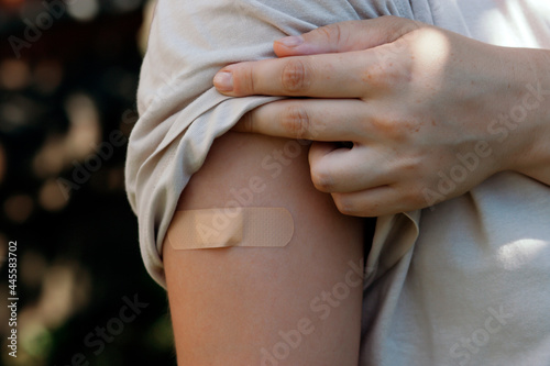 Foto Woman hand with a band-aid on her shoulder
