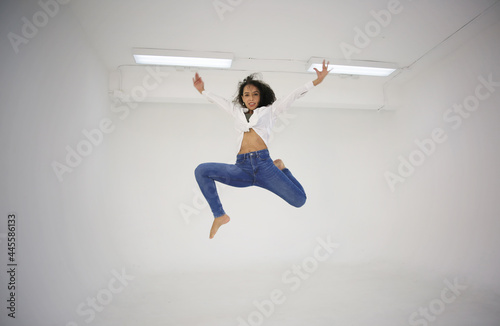 women stretching her leg and jump on mid air.