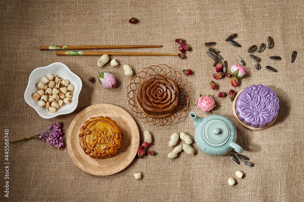Variety of moon cake on table. Mid autumn festival food and drink. Text translation: Pure Lotus Variety of moon cake on table. Mid autumn festival food and drink. Text translation: Pure Lotus