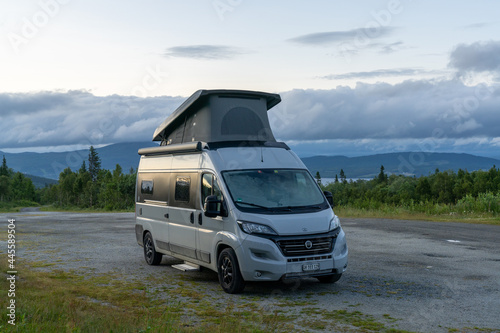 gray camper van with a pop-up roof parked in the wilderness of northern Sweden