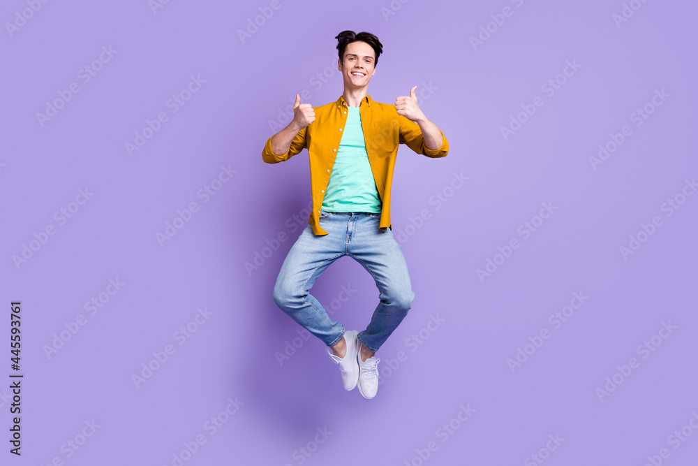 Full length photo of young man happy positive smile jump up show thumb-up fine isolated over violet color background