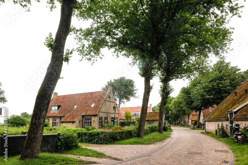 Street with houses and trees in the village of Nes on Ameland, one of the Dutch Wadden islands. photo