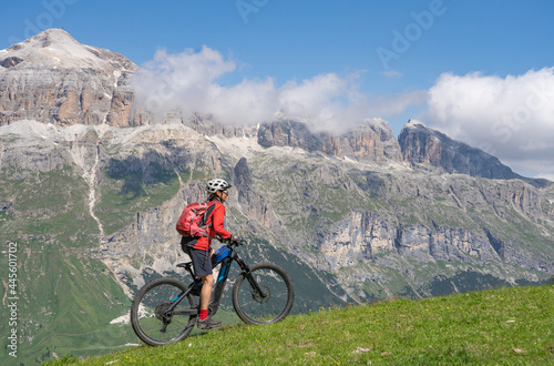 pretty active senior woman riding the famous Sella Ronda mountain bike Trail in Sella mountain group, Dolomites of Selva Wolkenstein, Val Gardena, South Tirol and Trentino, Italy