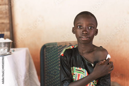 Relieved little black boy after having received a vaccine during a routine childhood immunisation schedule in a rural hospital setting photo