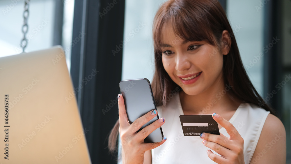 Cheerful happy shopaholic woman holding smartphone and credit card on her hand, shopping online. Cheerful happy shopaholic woman holding smartphone and credit card on her hand, shopping online.