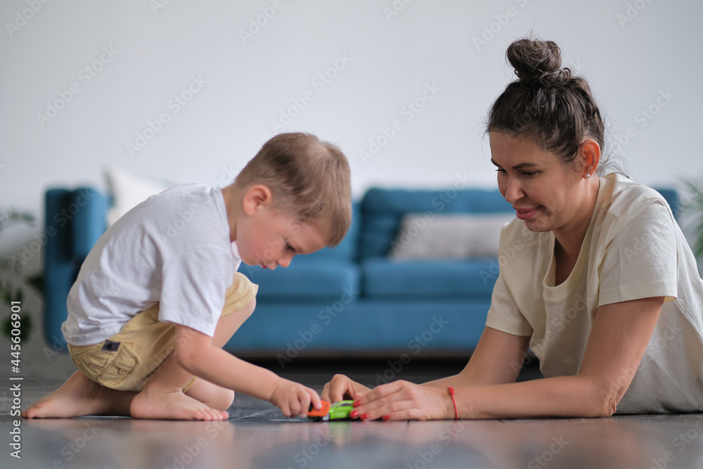 Expressive baby boy playing with a toy car with mother. Expressive baby boy playing with a toy car with mother.