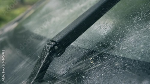 Spraying car windshield washer fluid slow motion, working wipers  photo