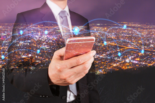 Double exposure of businessman use smartphone, communication 4G 5G node networking telephone cellsite and cityscape urban in the night as business, technology and telecom concept photo