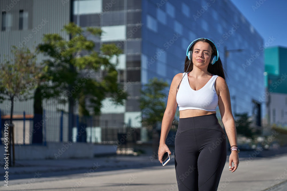 Fototapeta premium young woman exercising while listening to music with headphones