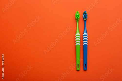 Toothbrushes on a orange background. Concept toothbrush selection. Oral cavity care. Dental hygiene. Top view.