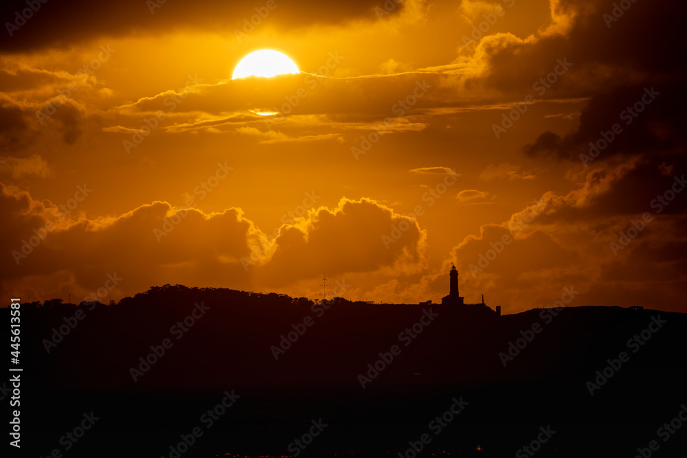Sunset on the beach of Loredo in the municipality of Somo in the province of Santander, with views of the lighthouse and large clouds