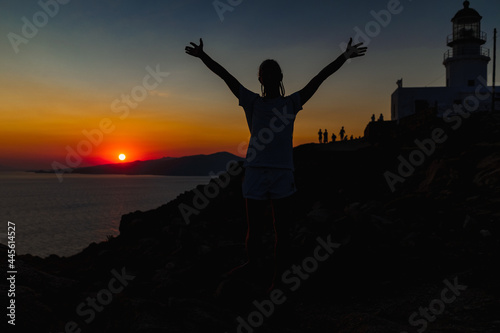 Silhouette of a happy young man person during a golden sunset in Mykonos, Greece