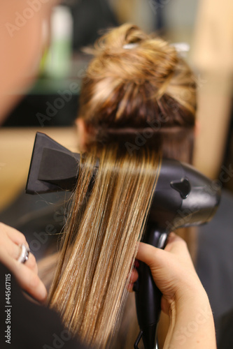 Stylist doing hairstyle beautiful brunette