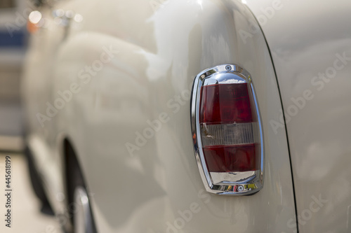 Closeup of a red brake light of a white retro car photo