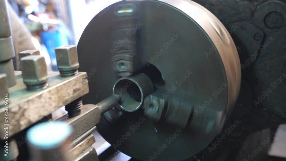 Close up of milling machine in action. View on rotating old workbench in garage or workshop. Mechanic or turner using lathe for metal processing. Slow motion