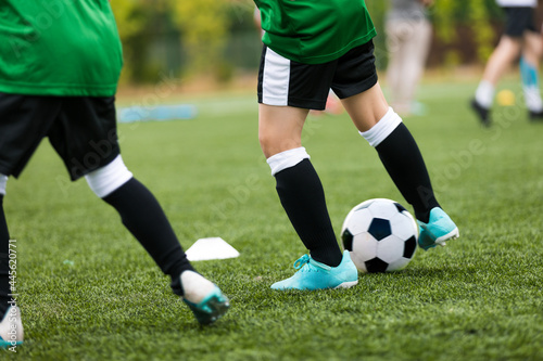 Legs of Soccer Players Kicking Balls on Training Pitch. Football Soccer Background. Football Practice For School Children