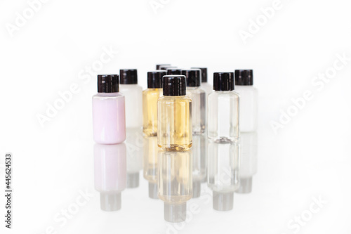 many multi-colored bottles with body and hair care products. with reflection in the middle of composition