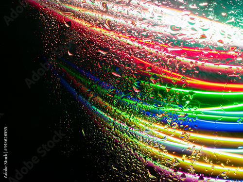 Misted glass, colorful abstract rainbow colored mist rain drops dew drops water droplets condensation on rainbow tinted glass window © SergeyKatyshkin