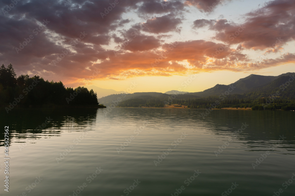 Colorful sunrise over calm lake in Colibita, Romania