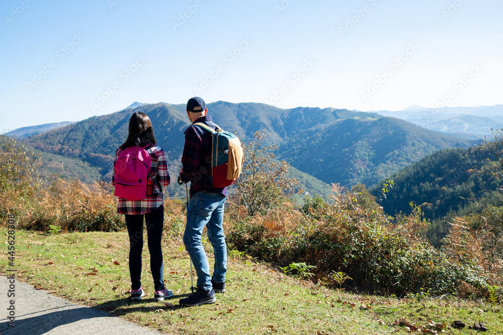 Father and his teenage daughter hiking  looking the landscape of mountains