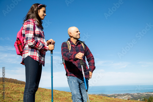 Father and teenage daughter hiking and enjoying the landscape