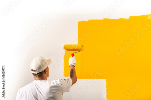 Male decorator painting a wall photo