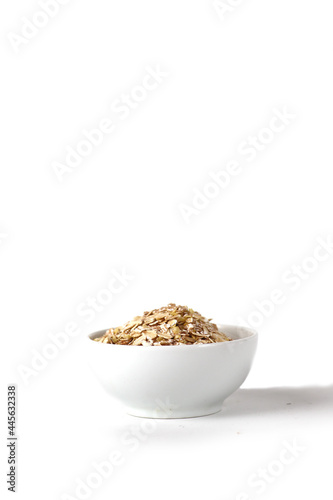 a bowl of oat flakes isolated on white background