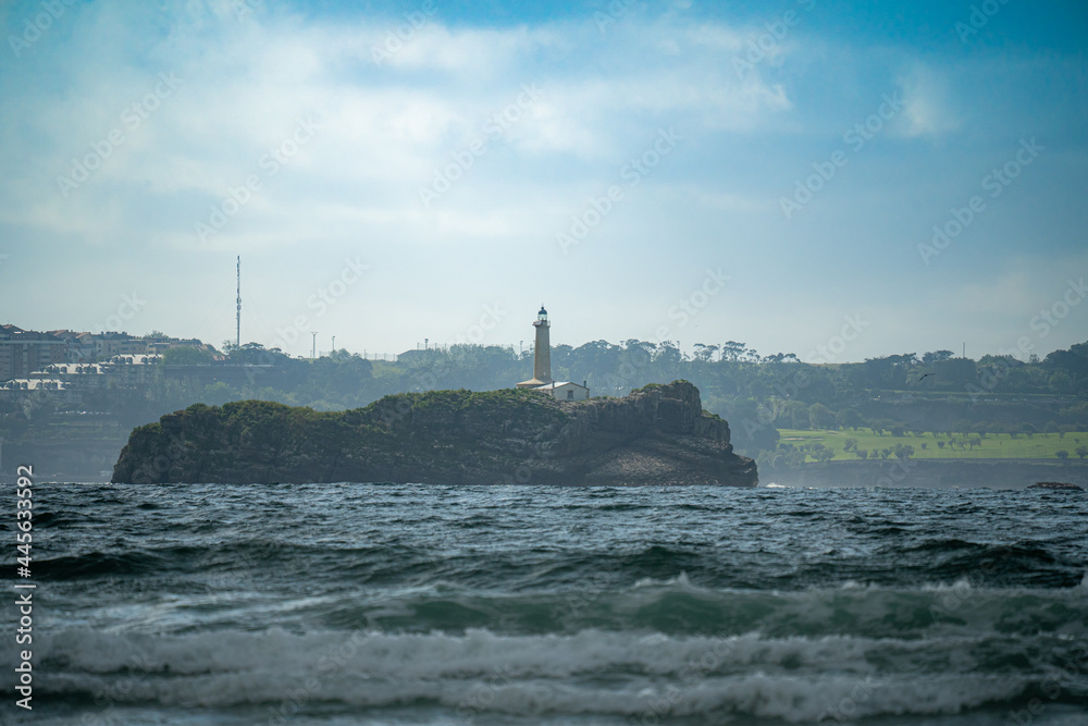 Lighthouse on the beach of Loredo in the municipality of Somo in the province of Santander, with views of the sea and the horizon