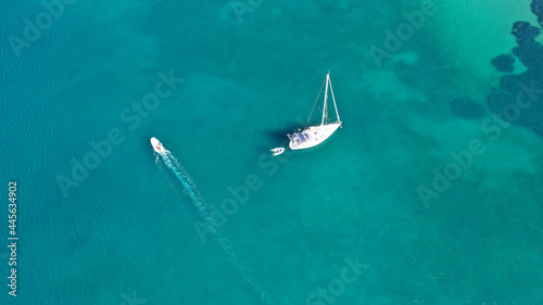 Aerial drone top down photo of sail boat anchored in tropical exotic paradise bay with emerald calm sea