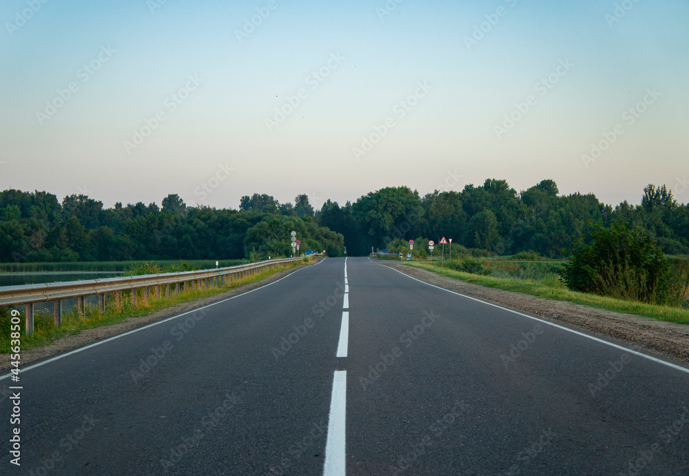 Fototapeta premium Calm empty asphalt road without cars at sunrise