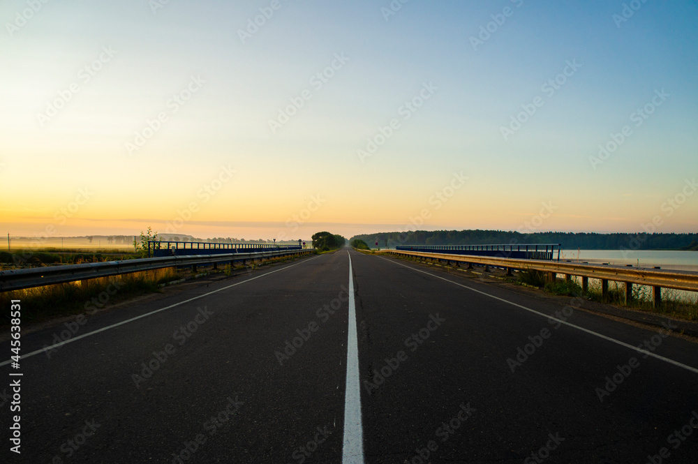 Calm empty asphalt road without cars at sunrise