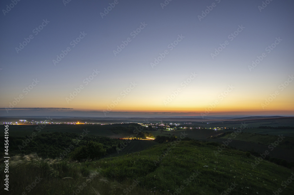 Beautiful sunrise over a field and a small town in summer in Ukraine